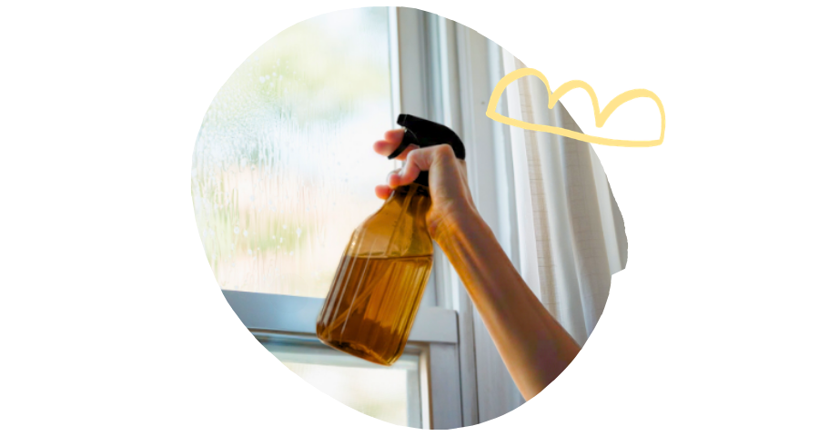 Main qui tient un vaporisateur spray en verre ambré avec solution de vinaigre d'alcool bio - Grand Beau 